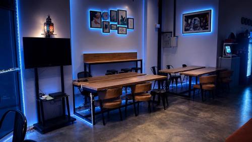 a room with two tables and chairs and a television at Hashtag.Capsule.Hostel in Johor Bahru