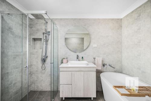 a bathroom with a tub and a sink and a shower at Sunset Escape in Summerland Point