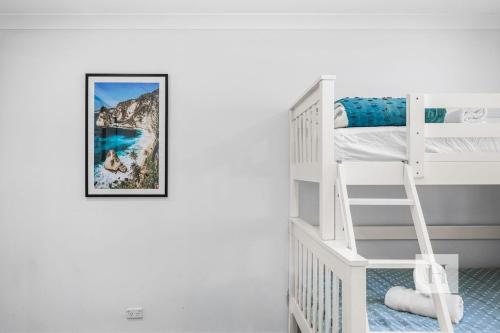 a bedroom with a bunk bed and a ladder at Sunset Escape in Summerland Point
