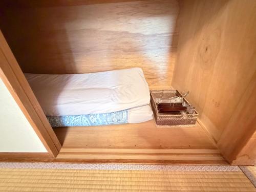 ein kleines Zimmer mit einem Bett in einem kleinen Zimmer in der Unterkunft 叶 in Nishikichō