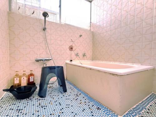 ein Badezimmer mit einer rosa Badewanne und einem schwarzen Wasserhahn in der Unterkunft 叶 in Nishikichō
