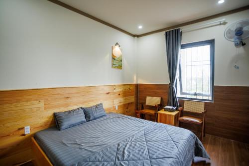 a bedroom with a blue bed and a window at Khách Sạn Vân Nguyên in Buôn Ea Yông