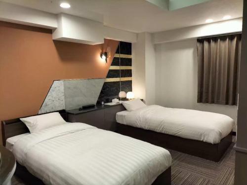 a room with two beds in a hotel room at 富士OUTLET Hotel in Gotemba