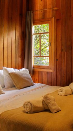 a bedroom with two beds and a window at Wesley House Hosteria Boutique in San Martín de los Andes