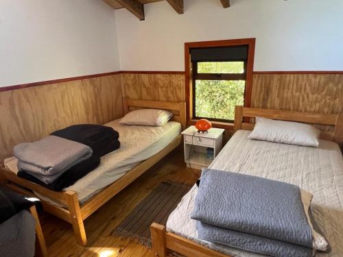 a bedroom with two beds and a window at Colibrí lodge in Recinto