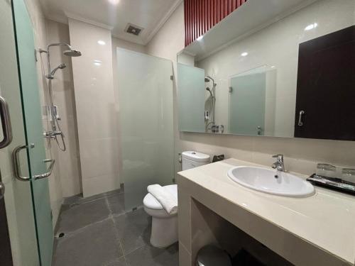 ein Badezimmer mit Waschbecken, Toilette und Dusche in der Unterkunft BBIB Suites in Wonorejo