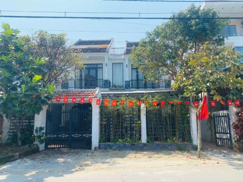 a house with a black gate with red garland at Laoxao Homestay in Hoi An