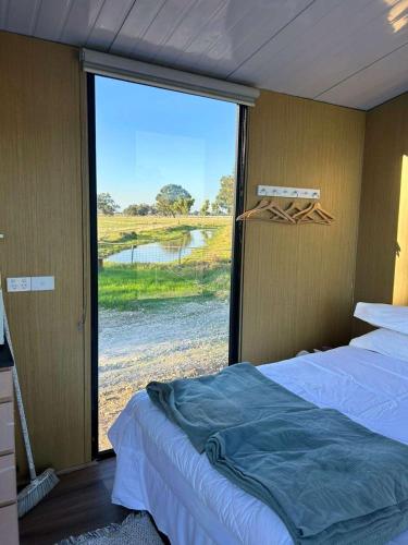 a bedroom with two beds and a large window at Ritaville by Tiny Away in Eaton