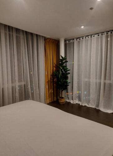 a bedroom with a bed and a window with curtains at Astoria Plaza Residential in Manila