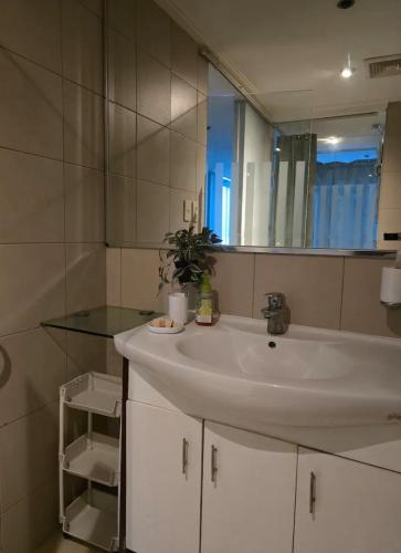 a bathroom with a white sink and a mirror at Astoria Plaza Residential in Manila