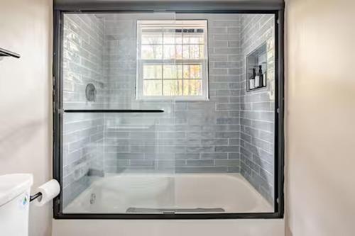 a bathroom with a bath tub with a window at Three Trees Retreat in Ellijay