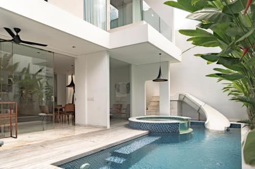 a house with a swimming pool and a slide at Eight Palms Villa Seminyak by Ini Vie Hospitality in Seminyak