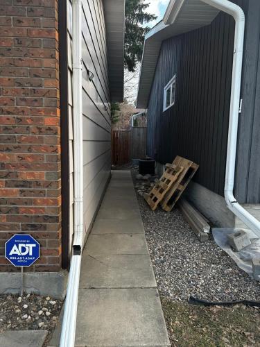 a side walk with a pile of wood next to a house at 1500 Sqft Entire Basement Cozy Private Suite in Saskatoon