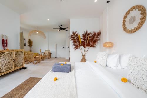 a bedroom with a white bed and a living room at Villa Ombak - 1BR Private Luxury Villa 150m from Seseh Beach in Canggu
