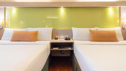 two beds sitting next to each other in a room at Microtel Inn & Suites by Wyndham San Fernando in San Fernando