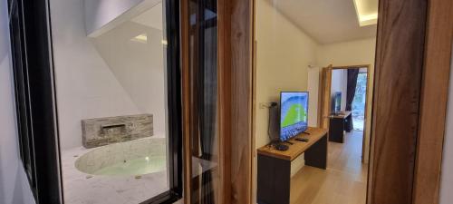 a bathroom with a tub with a television and a computer at Amara Resort Hua Hin in Hua Hin