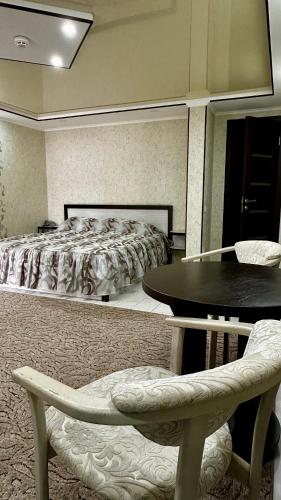 a bedroom with a bed and a table and a chair at Центральна Садиба in Kryzhanivka