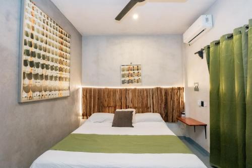 a small room with a bed and a window at Casa Shalom Green in Bacalar