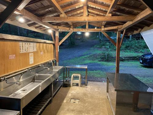 an outdoor kitchen with a sink in a pavilion at Camping field Kisokodo in Kiso-Fukushima
