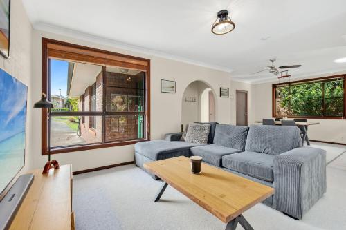 a living room with a couch and a table at Brodie Getaway in Coffs Harbour