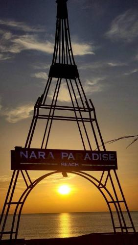 a sign in front of the eiffel tower at sunset at Nara Paradise Beach in Narathiwat