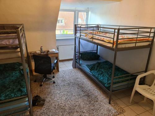 a room with two bunk beds and a desk at einfacher Schlafplatz ohne Ansprüche in Essen