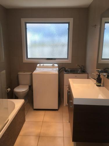 a bathroom with a toilet and a sink and a window at Azure in Bridport