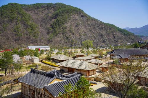 a group of buildings with a mountain in the background at 청송 한옥호텔 안 in Imjŏn-dong
