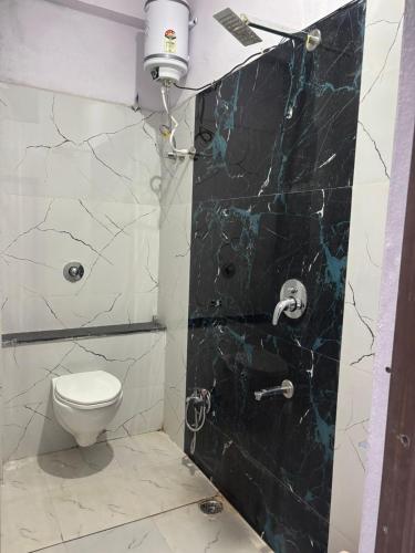a bathroom with a toilet and a shower at Dixit's Residency in Godarpura