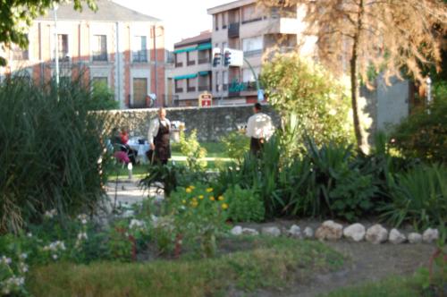 a group of people walking around a garden at Hostal San Francisco in Cuéllar