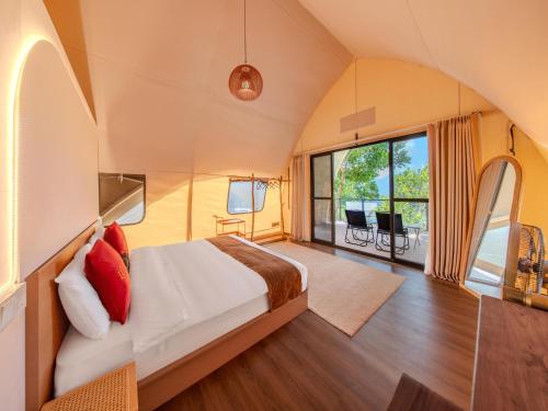a bedroom with a bed and a large window at Lù Yīng Retreats in Bukit Tinggi