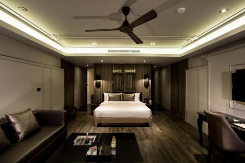 a hotel room with a bed and a couch at De Chai the Deco Chiang Mai - SHA Plus in Chiang Mai
