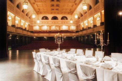 a large room with white tables and chairs in a building at Dolce by Wyndham Bad Nauheim in Bad Nauheim