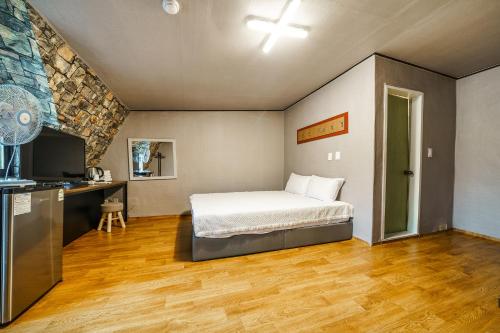 a bedroom with a bed and a desk and a television at Seorak HOT Spring Mammoth Resotel in Sokcho