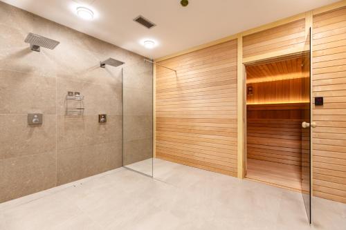 a bathroom with a shower and a glass door at Lira Bay in Igalo