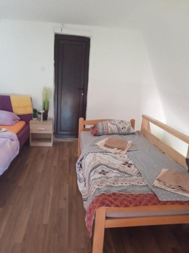 a bedroom with two beds and a wooden floor at Vikendica Dunav i SAVA in Donji Milanovac