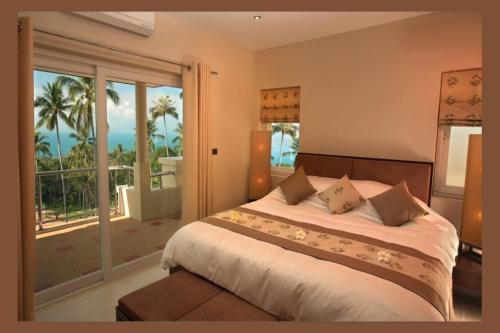a bedroom with a bed with a view of the ocean at Kalara Gardens in Ban Bang Po