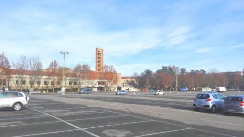 a parking lot with cars parked in front of a building at Luna del Belvedere in Asti
