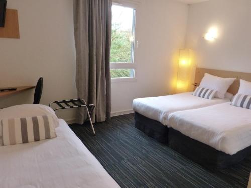 ein Hotelzimmer mit 2 Betten und einem Fenster in der Unterkunft Hotel Premium in Forbach