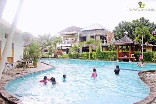 a group of children playing in the swimming pool at a resort at Sierra Villa Malang in Malang