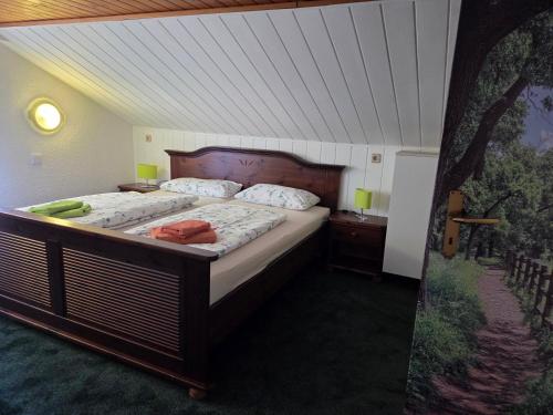 a bedroom with a large bed with a wooden headboard at Ferienhaus Olbersdorf in Olbersdorf