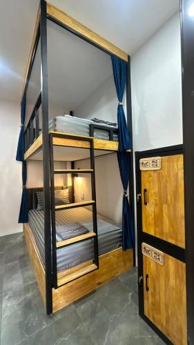 a room with bunk beds with blue curtains at Cosy Hostel in Ko Tao