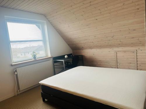 a bedroom with a white bed in a attic at Family private house in Brovst