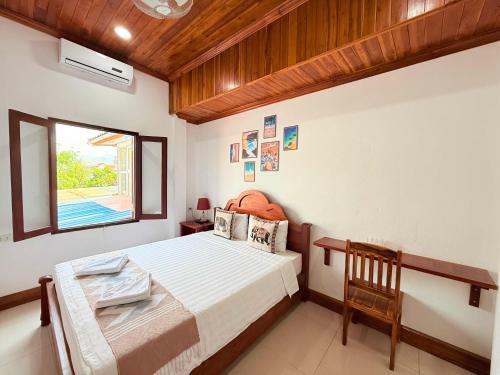 a bedroom with a bed and a window at Elephant Hotel Luang Parabang in Luang Prabang