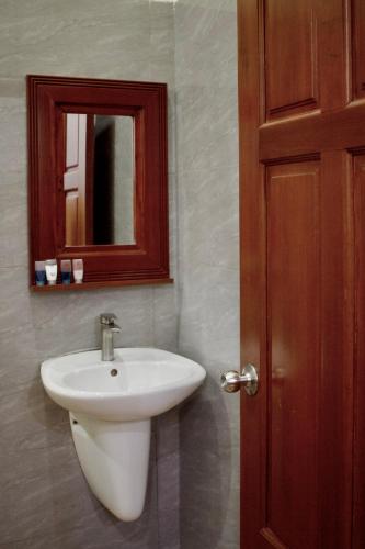 a bathroom with a white sink and a mirror at Nhà Nghỉ Thi Anh in Ấp Bia