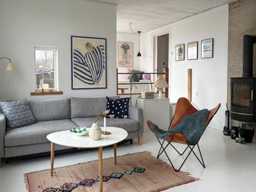 a living room with a couch and a table and chairs at Functionalist House Only 100 Steps To The Beach in Haderslev