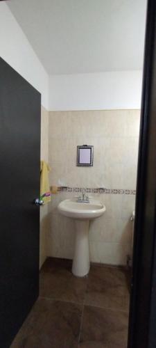 a bathroom with a white sink and a mirror at Hospedaje "Entre Amigos" in Comalcalco