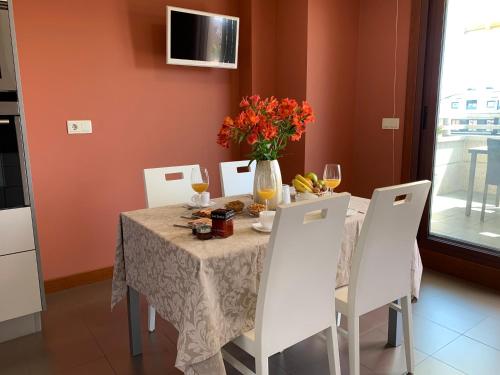 a dining room table with a vase of flowers on it at CANELAS CLASS con AMPLIAS TERRAZAS in Portonovo
