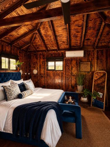 a bedroom with a large bed and a blue chair at Sunset Calm Retreat Bungalow in Haleiwa