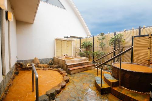 baño grande con bañera y lavamanos en Arima Hot Spring Ryokan Hanamusubi en Kobe